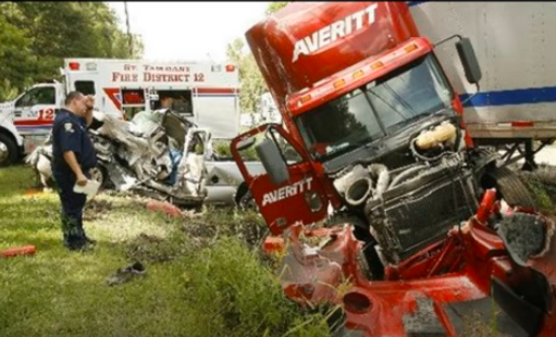 A red truck and other vehicles in the grass.